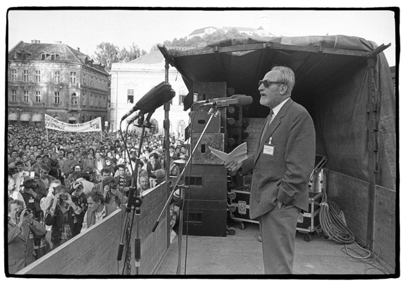 A speaker addressing a rally in Ljubljana, with the castle on the hill behind